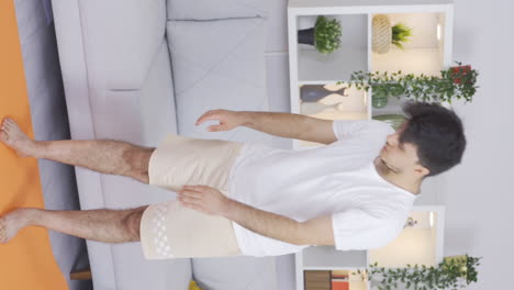 Vertical-video-of-Man-exercising-at-home-stretching-his-arms.-Healthy-life-fitness.